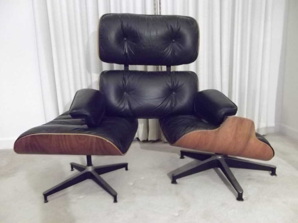 Eames lounge chair and ottoman with black leather cushions and wood veneer shells