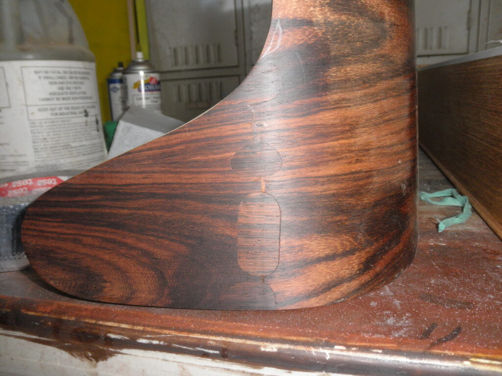 Repaired Eames lounge chair shell with rosewood veneer grain in the workshop