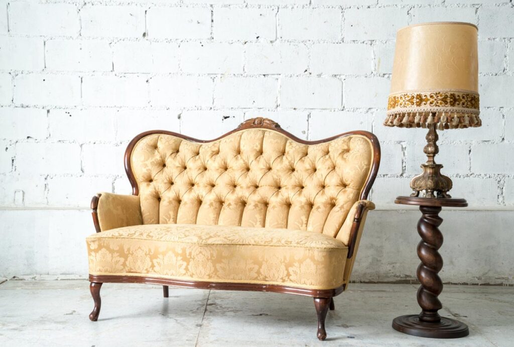Historic carved wood-frame settee with deep button-tufted curved back