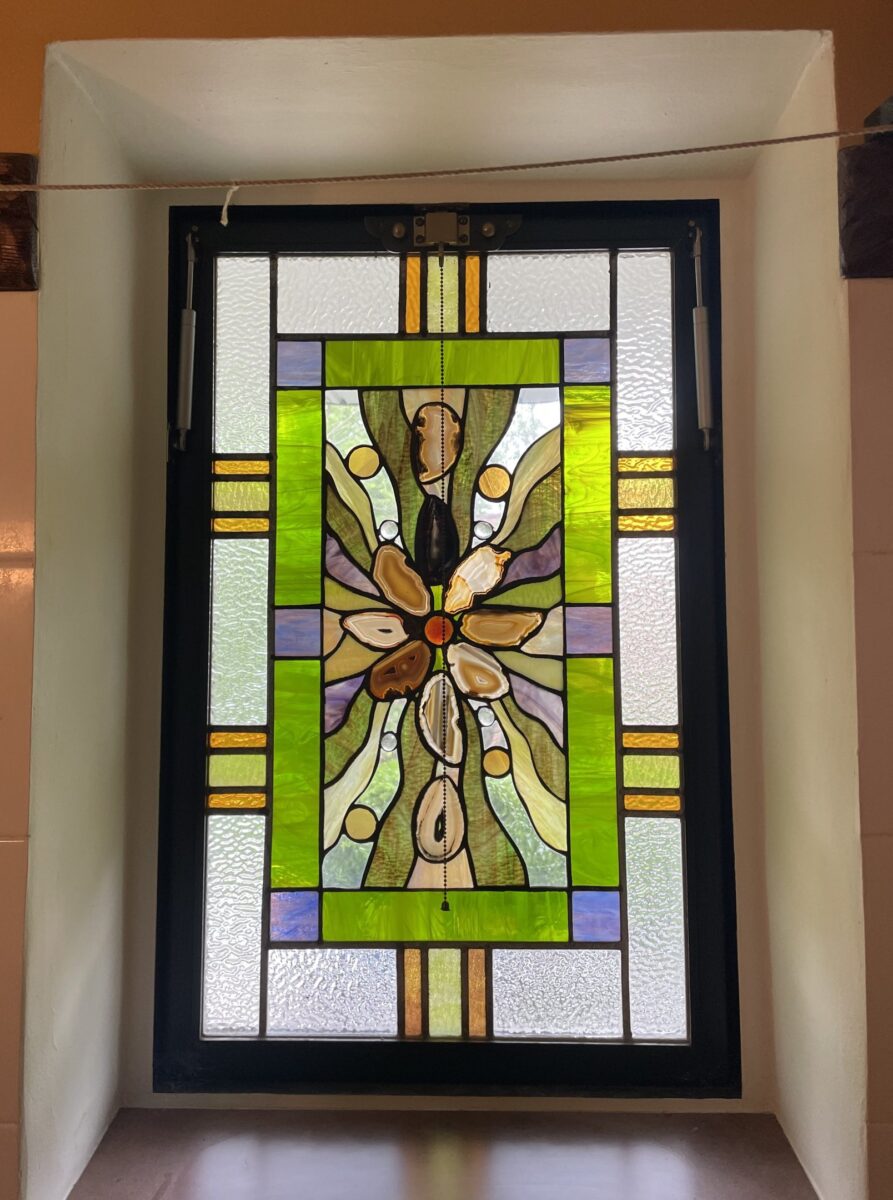 Custom leaded glass window with green borders and inset natural geode slices