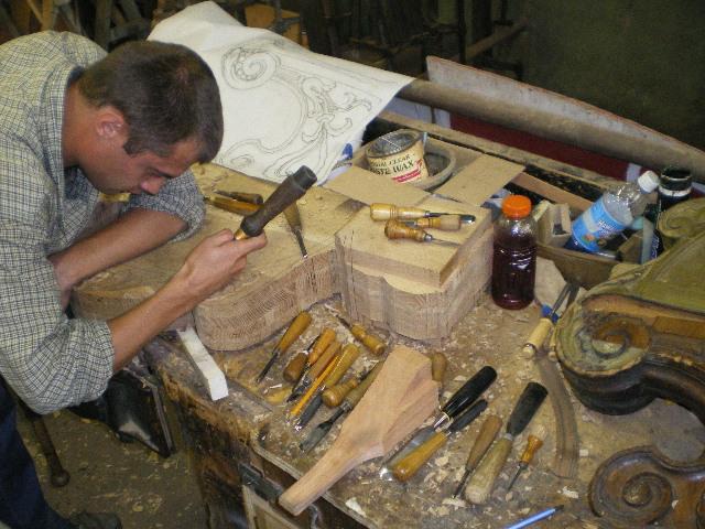 Olek craftsman carving a solid oak architectural component