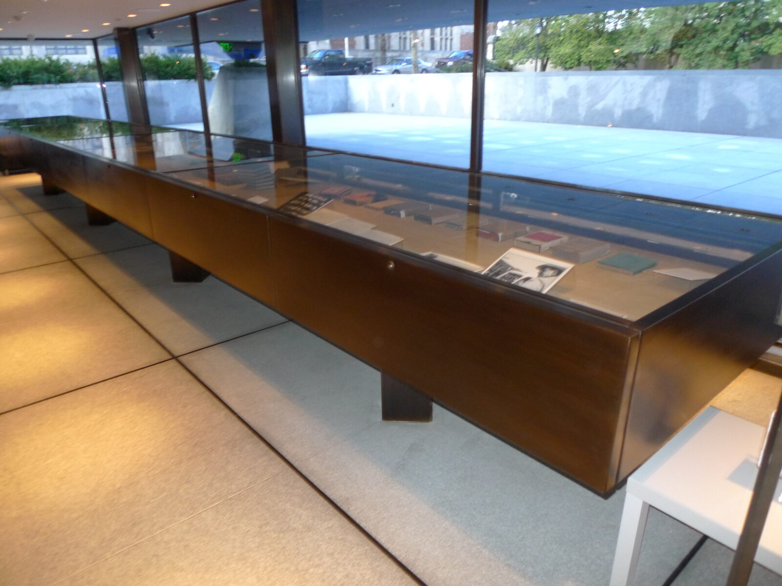 Bronze-framed glass exhibition vitrine with displayed books and photographs at Yale Beinecke Library